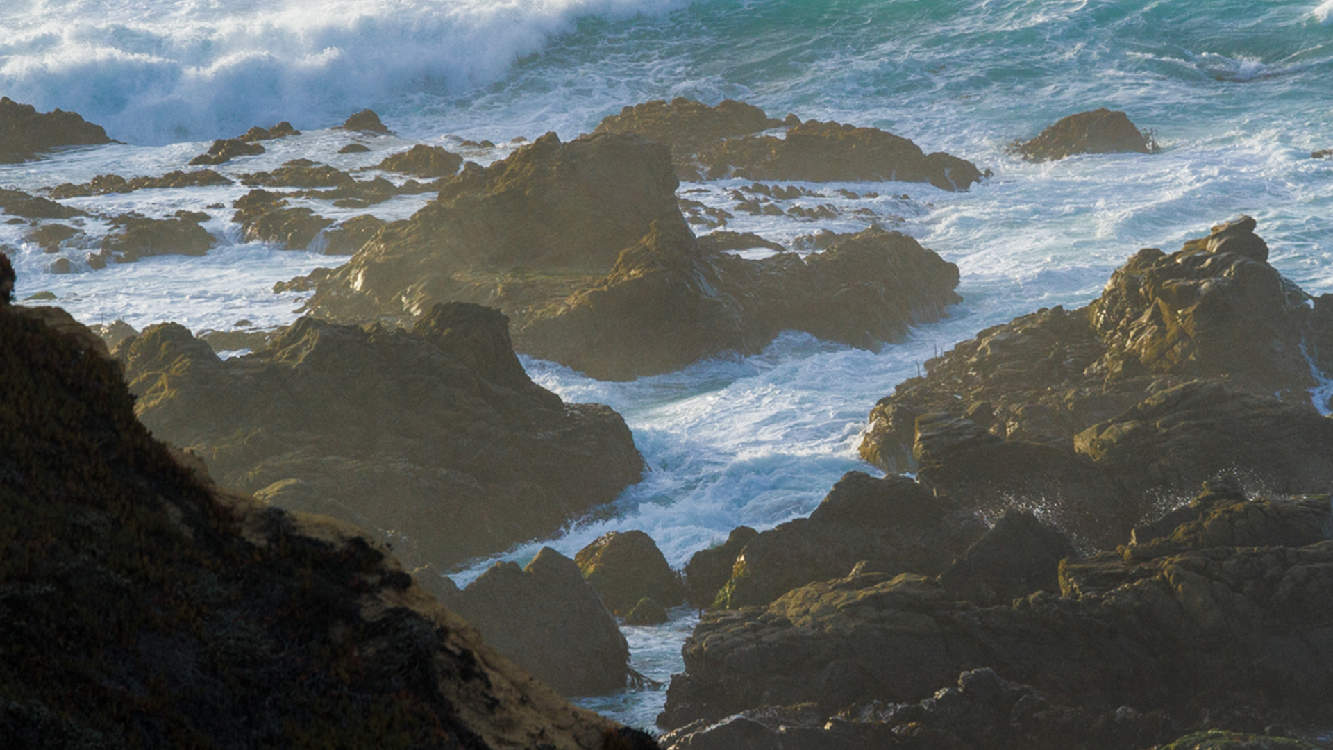 telephoto compressed rocky beach, waves crash
